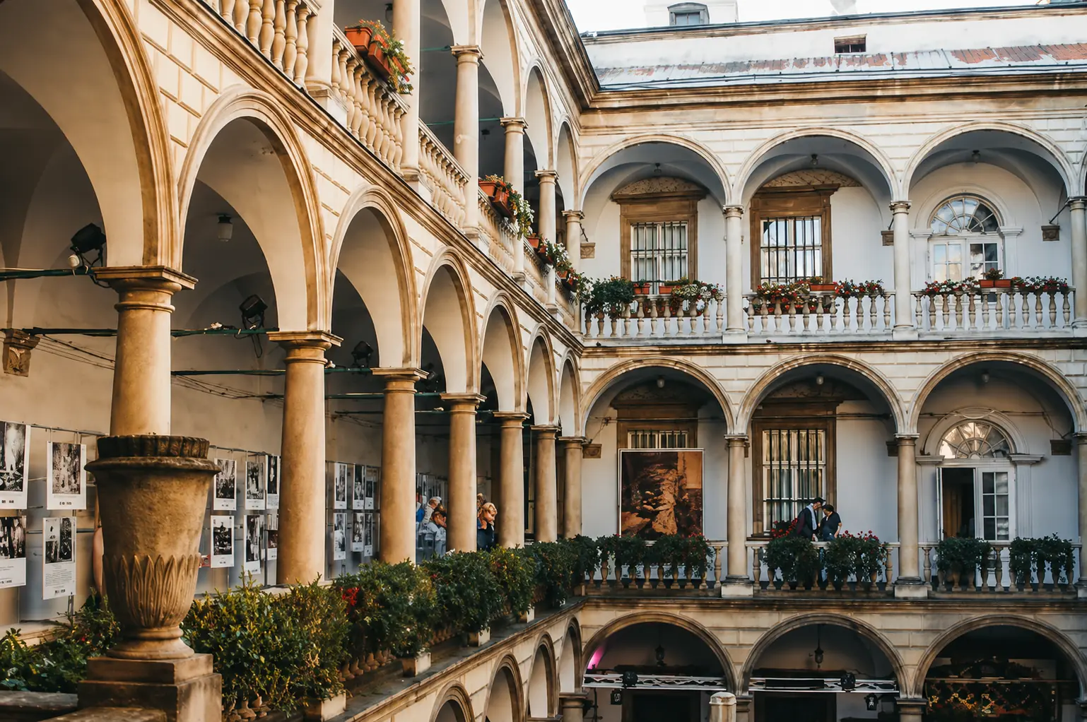 Galleries of the Italian Courtyard with arches and flowers, photo by BANKHOTEL